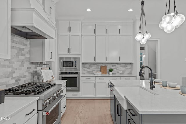 kitchen featuring stainless steel appliances, custom range hood, light wood finished floors, and white cabinetry