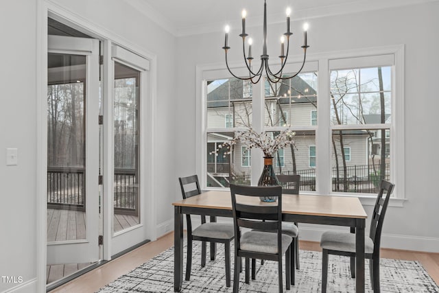 dining room with plenty of natural light, baseboards, a notable chandelier, and wood finished floors