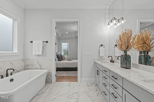 ensuite bathroom featuring double vanity, marble finish floor, ornamental molding, and a sink