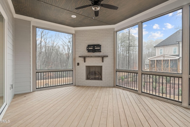 unfurnished sunroom featuring plenty of natural light, wooden ceiling, and a ceiling fan