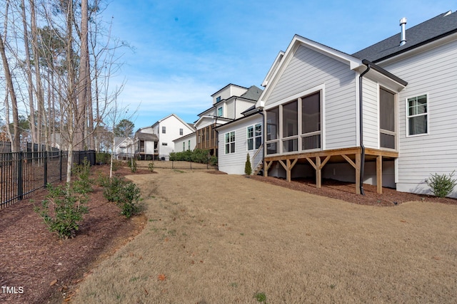 rear view of house with a residential view, a sunroom, and a fenced backyard