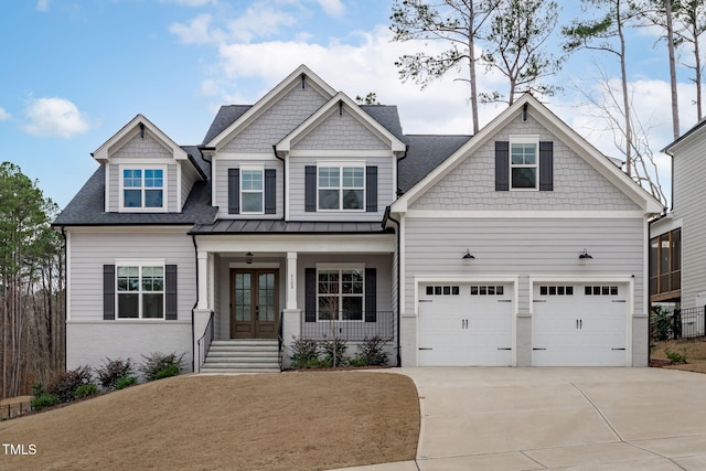 craftsman-style home with a garage, french doors, covered porch, and driveway