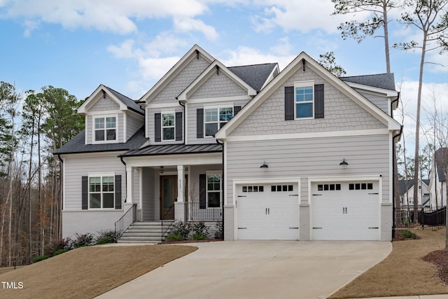 craftsman-style house featuring metal roof, a porch, an attached garage, driveway, and a standing seam roof