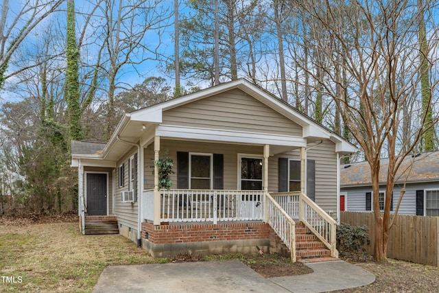 view of front of house featuring covered porch, crawl space, and fence