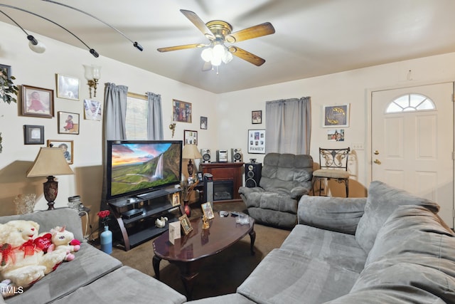 living area with carpet, a fireplace, and a ceiling fan