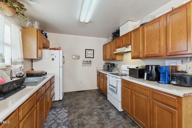 kitchen featuring under cabinet range hood, electric stove, light countertops, stone finish flooring, and brown cabinetry