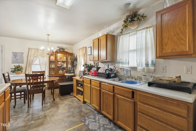 kitchen with light countertops, brown cabinetry, and a sink