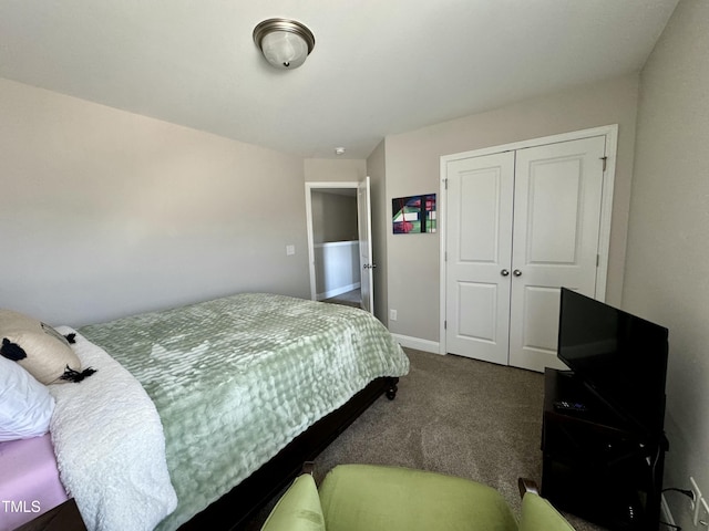 bedroom with baseboards, dark colored carpet, and a closet