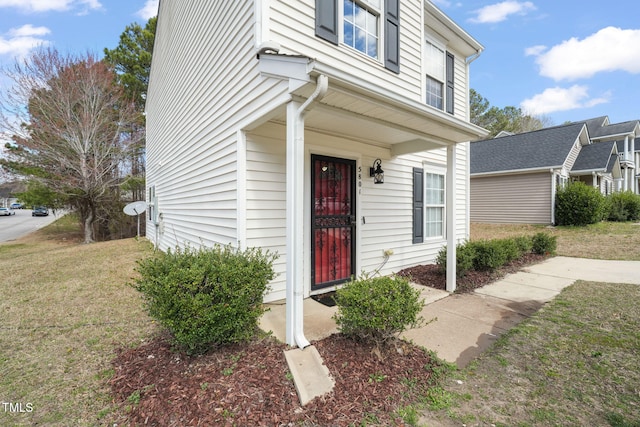 property entrance with a lawn