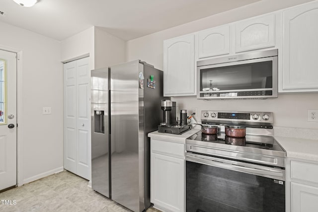 kitchen with stainless steel appliances, light countertops, and white cabinets