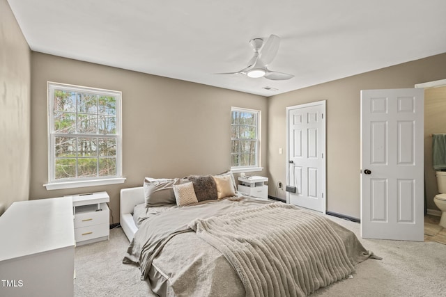 bedroom featuring light carpet, multiple windows, a ceiling fan, and baseboards