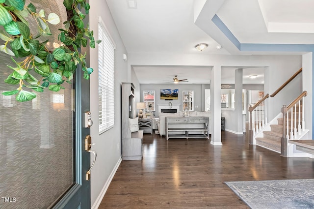 entryway with stairs, baseboards, dark wood-style flooring, and a ceiling fan