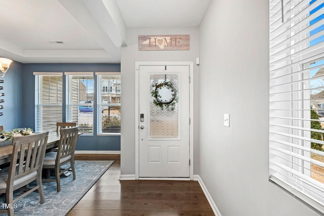 foyer with visible vents, baseboards, and dark wood-style flooring