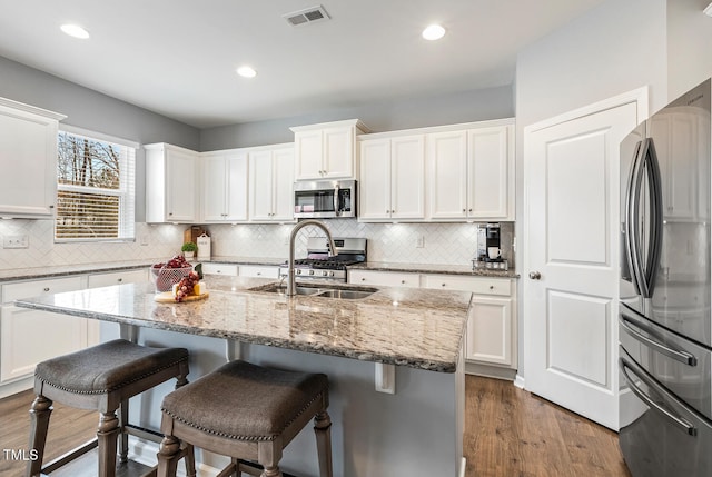 kitchen featuring visible vents, appliances with stainless steel finishes, dark wood-style flooring, and a sink