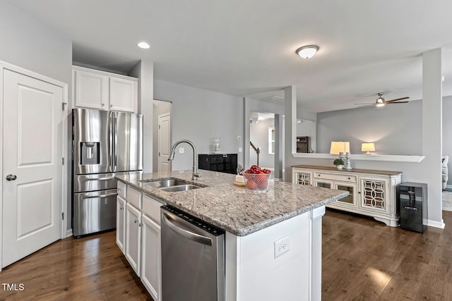 kitchen with a sink, stainless steel appliances, white cabinets, and dark wood-style flooring