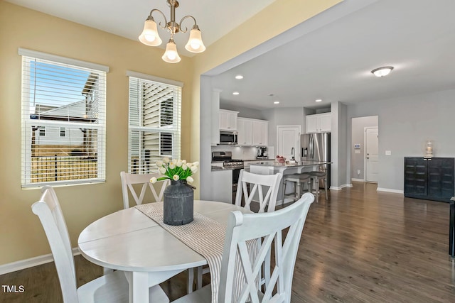 dining room featuring dark wood-style floors, a notable chandelier, and baseboards