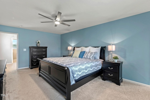 bedroom featuring light carpet, a ceiling fan, and baseboards