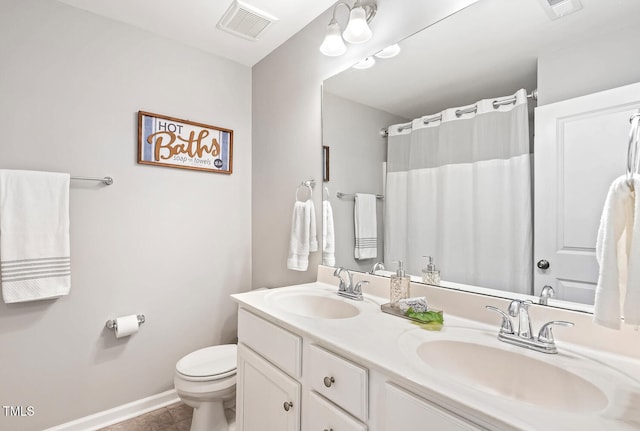 bathroom featuring toilet, visible vents, and a sink