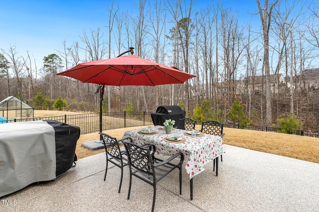 view of patio featuring outdoor dining area, a grill, and fence