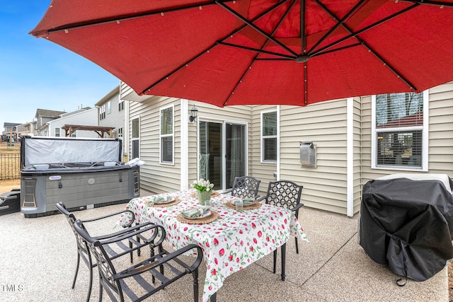 view of patio / terrace featuring outdoor dining space, fence, a hot tub, and grilling area