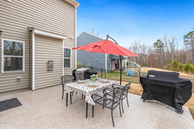 view of patio with a grill, outdoor dining space, and fence