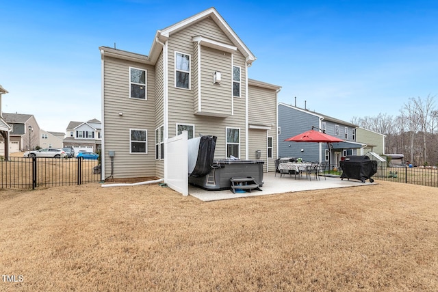 rear view of property with a patio area, a hot tub, a yard, and fence