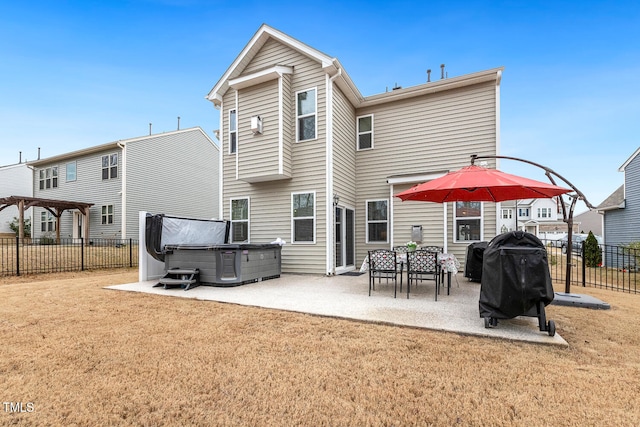 rear view of property with fence, a yard, a pergola, a hot tub, and a patio area