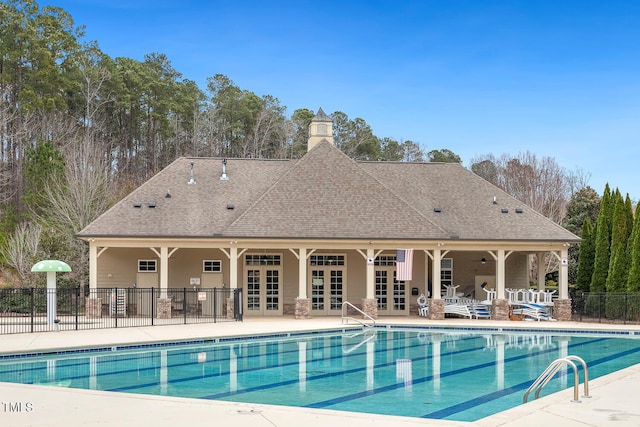 pool with french doors, a patio, and fence