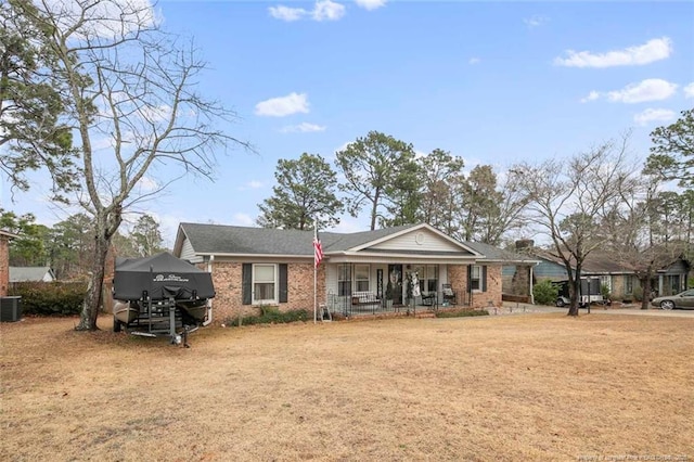 view of front facade with covered porch, brick siding, a front lawn, and central air condition unit