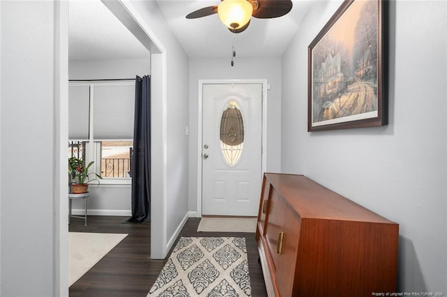 foyer with ceiling fan, dark wood-style flooring, and baseboards