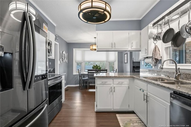 kitchen featuring stainless steel appliances, dark wood-type flooring, white cabinets, a sink, and light stone countertops