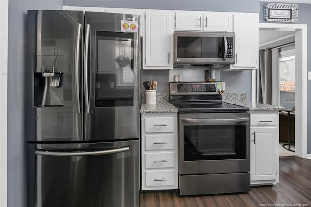 kitchen with stainless steel appliances, dark wood-type flooring, light stone countertops, and white cabinets