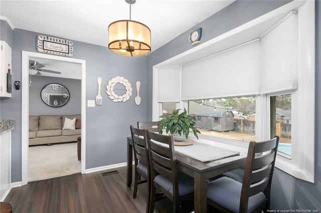 dining area featuring dark wood-style floors, ceiling fan, visible vents, and baseboards