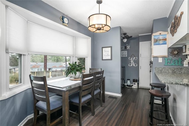 dining room featuring a textured ceiling, baseboards, and dark wood-style flooring