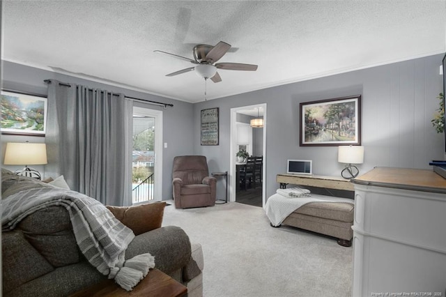 interior space with ceiling fan, access to outside, a textured ceiling, crown molding, and carpet flooring