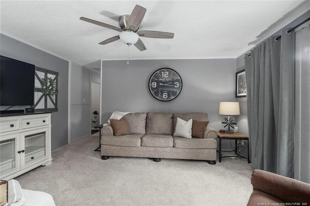 carpeted living room with ornamental molding and a ceiling fan