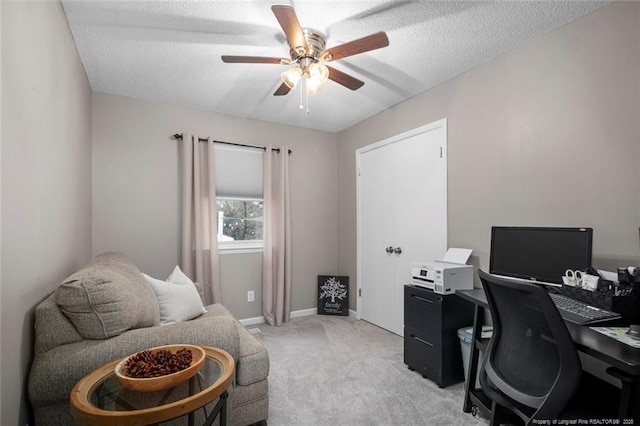 office space with a ceiling fan, light colored carpet, a textured ceiling, and baseboards