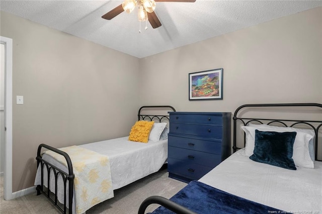 carpeted bedroom featuring a textured ceiling, a ceiling fan, and baseboards