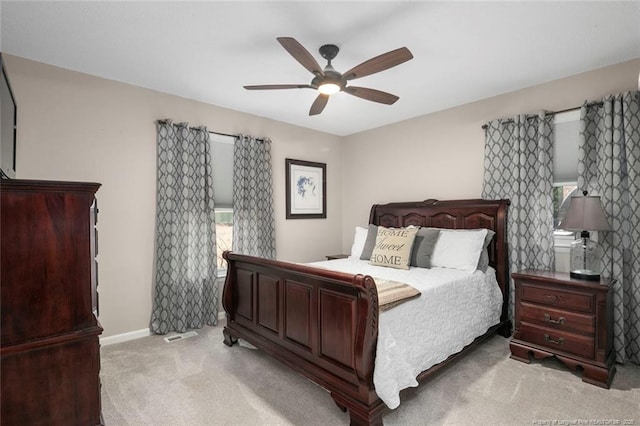 bedroom featuring light carpet, a ceiling fan, and baseboards