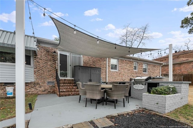 view of patio / terrace featuring entry steps, an outdoor kitchen, a grill, fence, and outdoor dining area