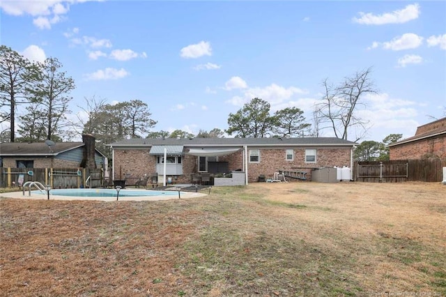 rear view of property featuring a lawn, fence, a fenced in pool, and a patio