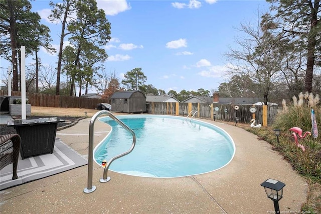 view of pool with an outbuilding, a patio, a fenced backyard, a storage shed, and a fenced in pool