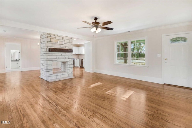 unfurnished living room with ornamental molding, a fireplace, and light wood finished floors