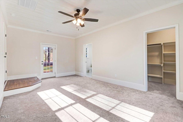 carpeted spare room featuring baseboards, a ceiling fan, and crown molding