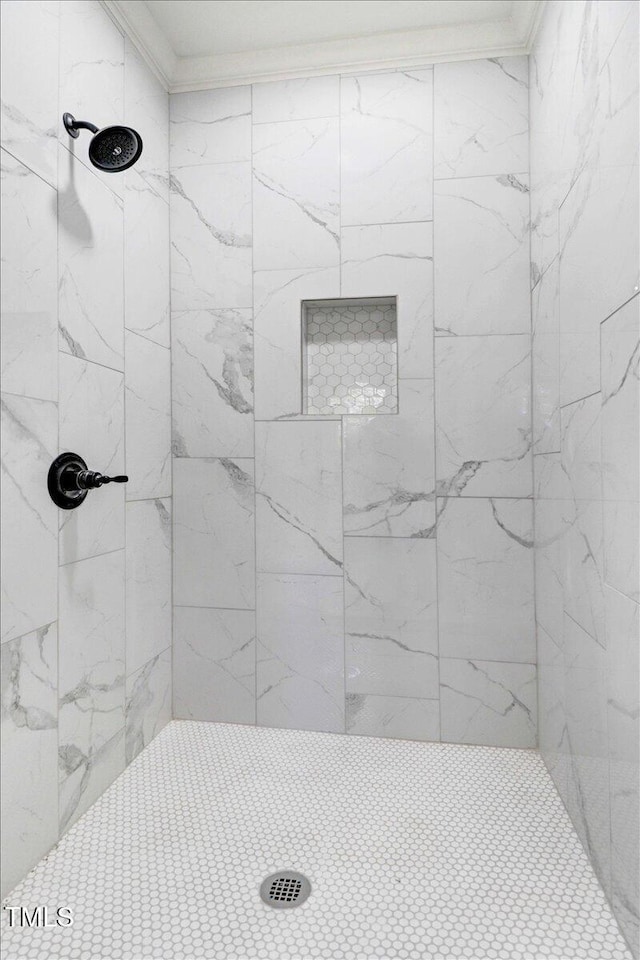 full bathroom with tiled shower and crown molding