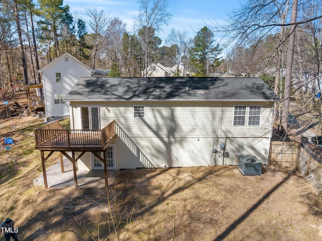 back of property with cooling unit, a wooden deck, and fence