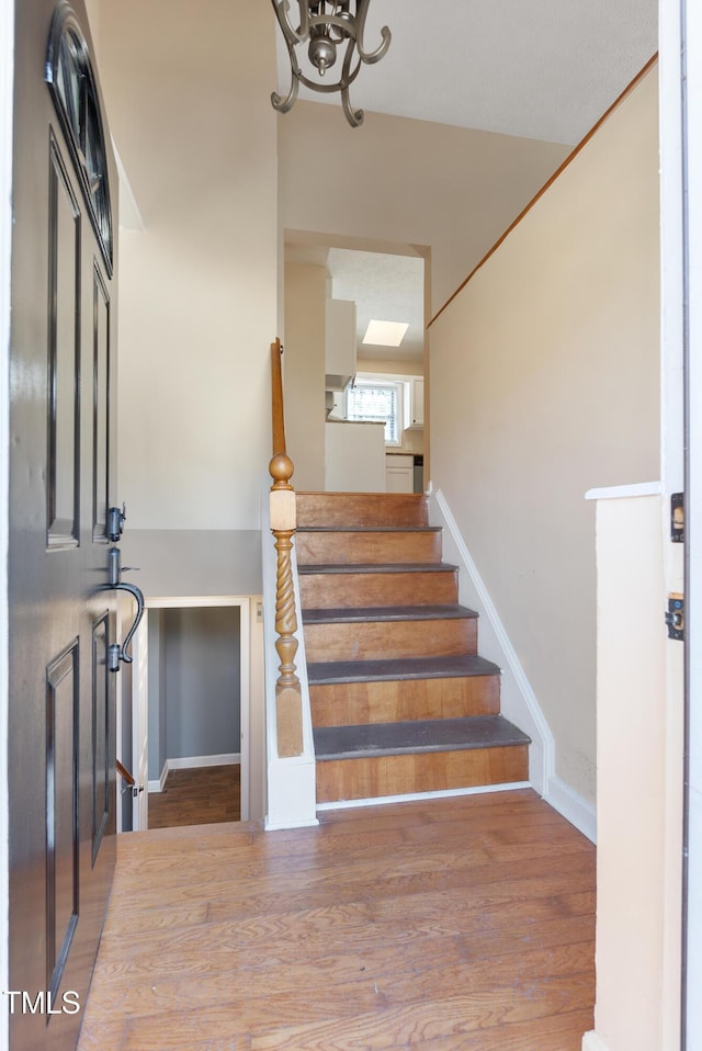 stairway with baseboards and wood finished floors