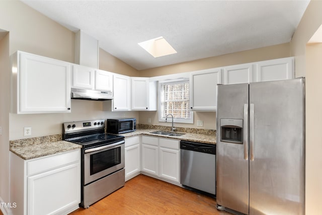 kitchen featuring stainless steel appliances, a sink, white cabinetry, and under cabinet range hood