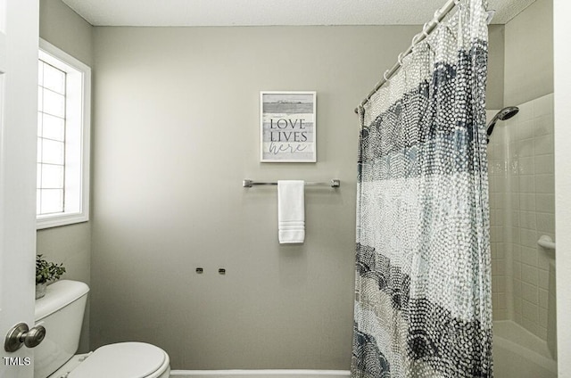 full bath featuring curtained shower, baseboards, and toilet