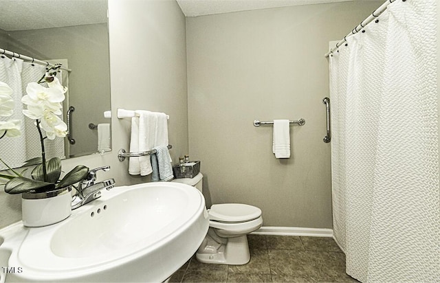 full bath with curtained shower, toilet, a sink, tile patterned flooring, and baseboards